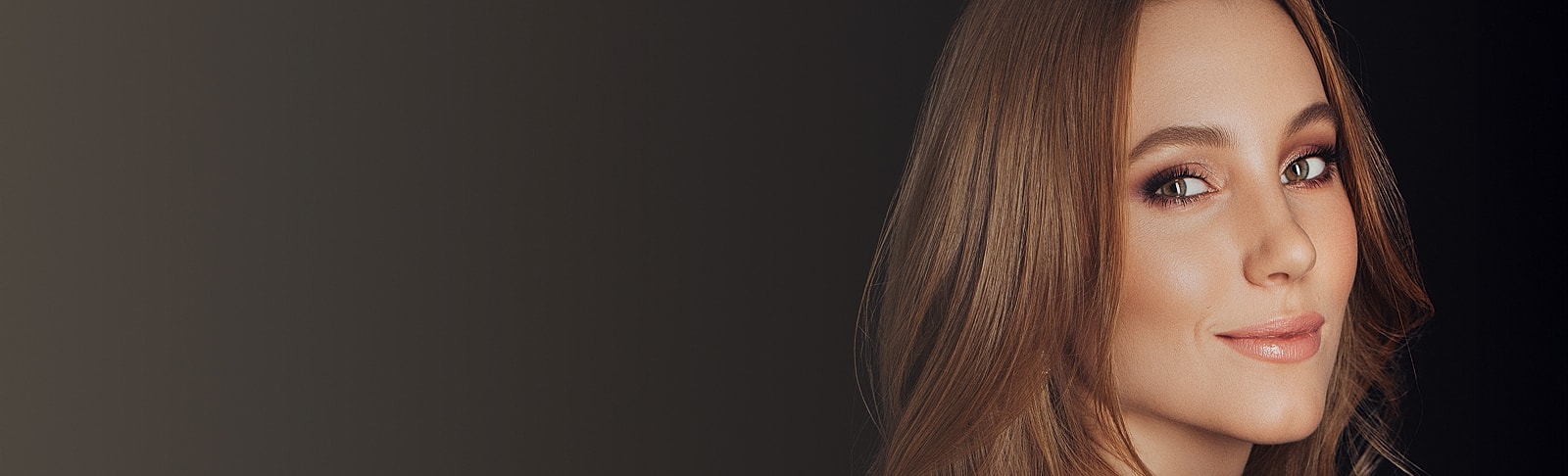 Woman with long hair smiling softly at camera.