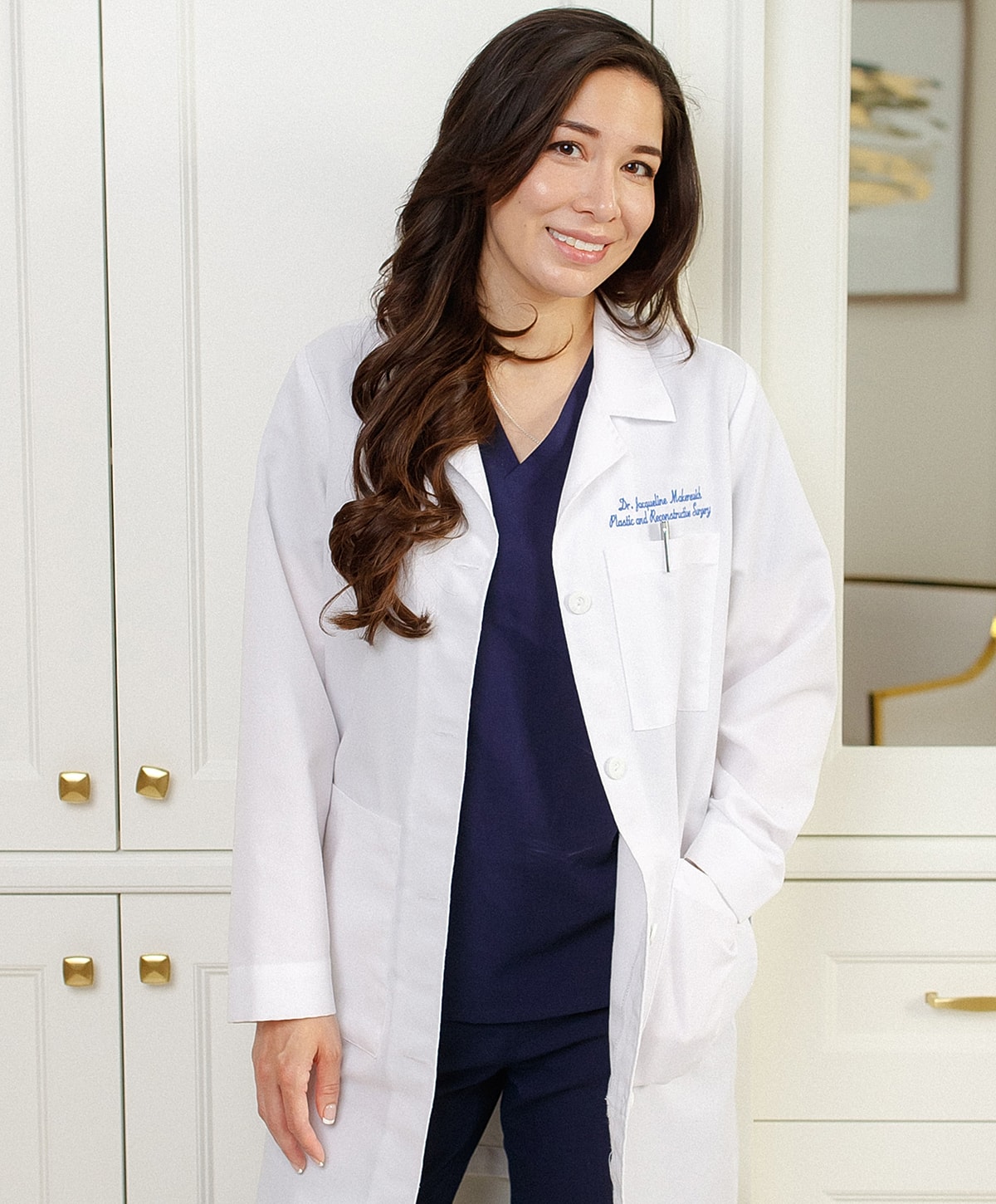 Medical professional in white coat and scrubs.