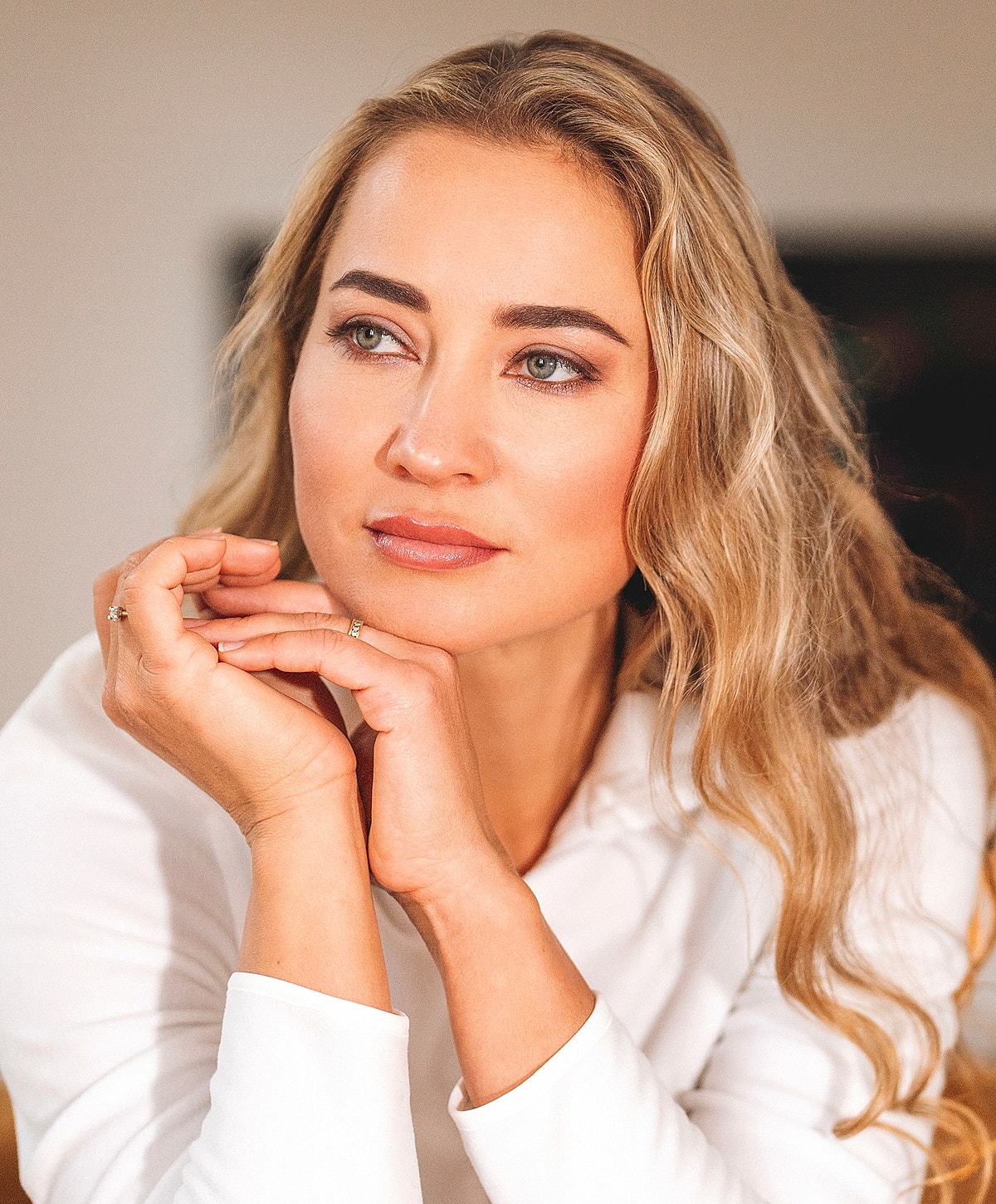 Thoughtful woman with wavy blonde hair.