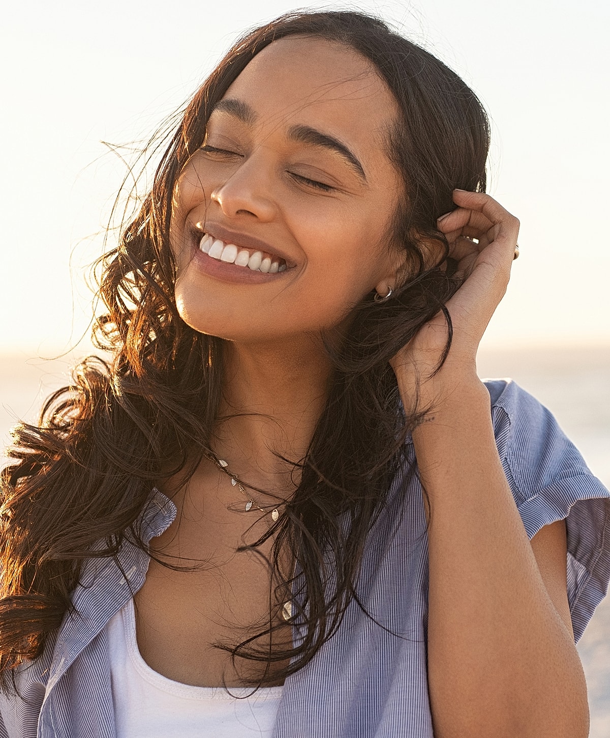 Smiling woman with long hair at sunset.