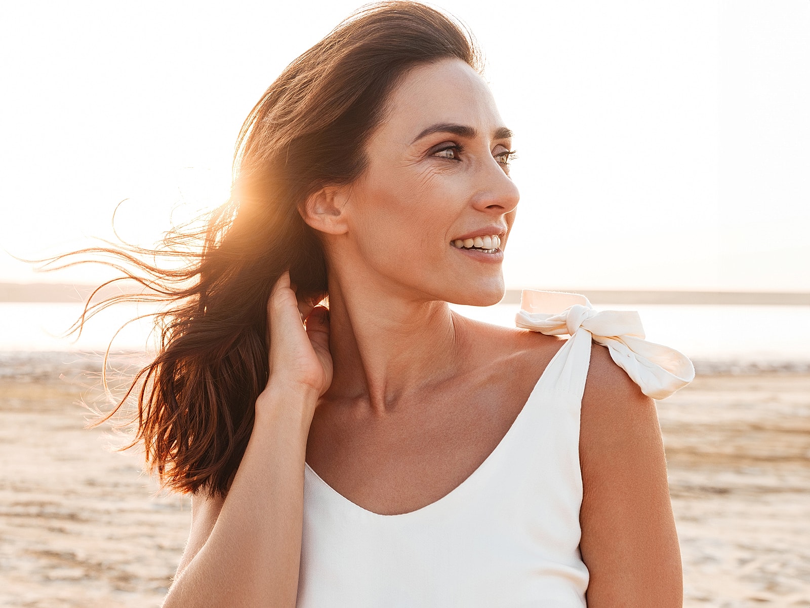 Female doctor in white coat smiling indoors.